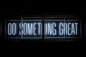 a neon sign stating, do something great