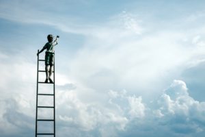 A person on a ladder reaching for their goals